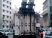 음식물 쓰레기 수거 사진 2 : 음식물 쓰레기 통을 수거 차량에 부착된 기계로 쏟아 넣는 사진